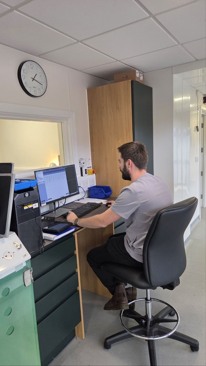 A veterinary professional working at an imaging workstation.