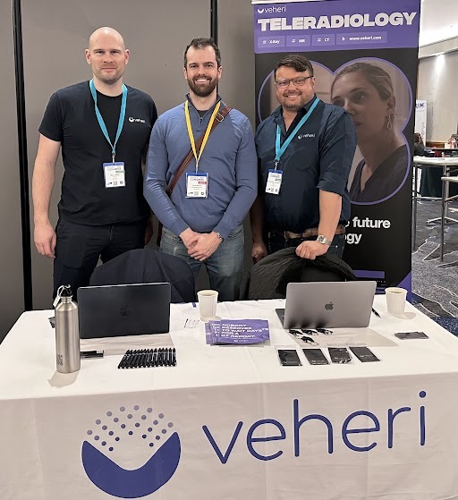 Three Veheri team members at a veterinary teleradiology conference stand.